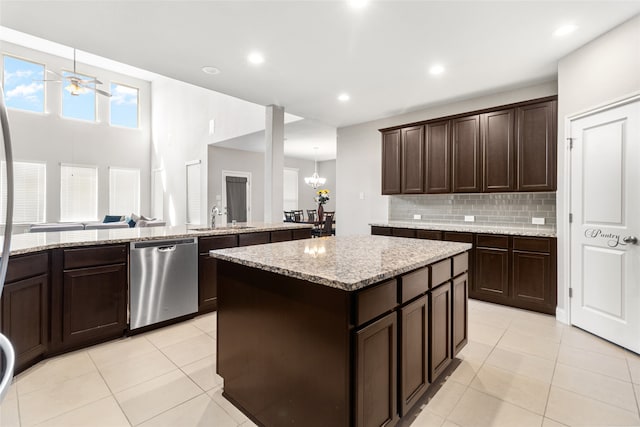 kitchen featuring light tile patterned flooring, dark brown cabinetry, dishwasher, and a kitchen island