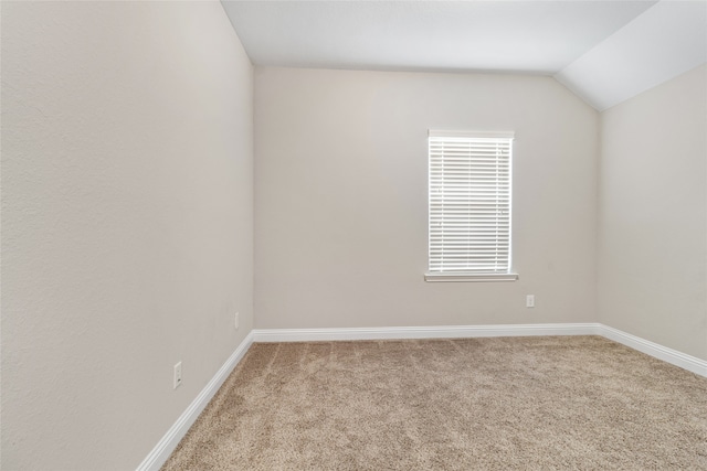 carpeted empty room with lofted ceiling