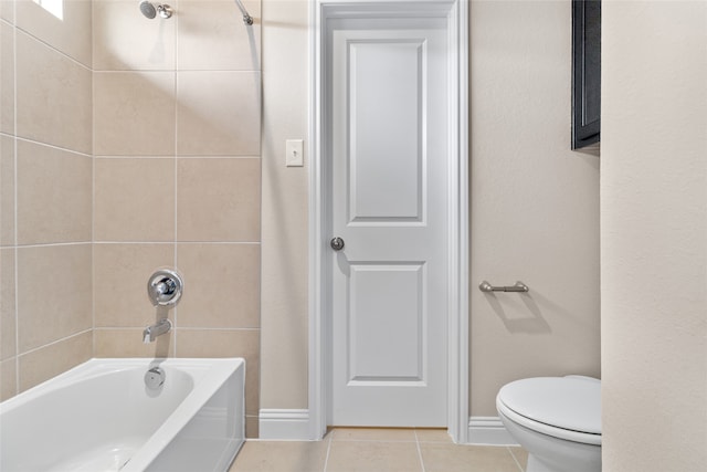 bathroom with tiled shower / bath, tile patterned floors, and toilet