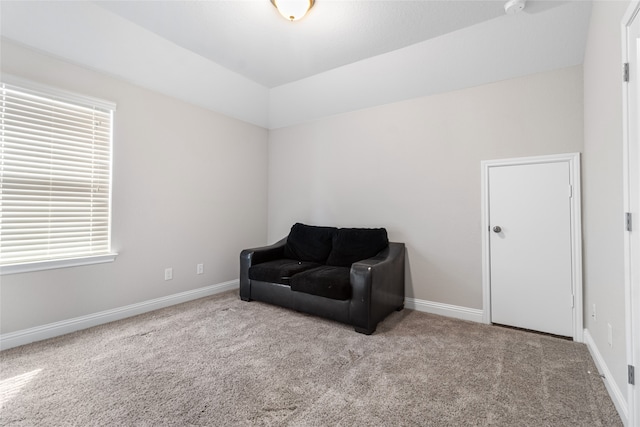 living area featuring vaulted ceiling and light carpet