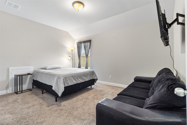 bedroom with light colored carpet and vaulted ceiling