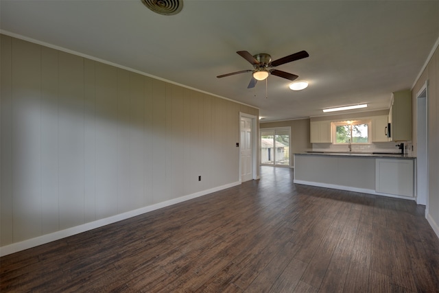 unfurnished living room featuring crown molding, dark wood-type flooring, and ceiling fan