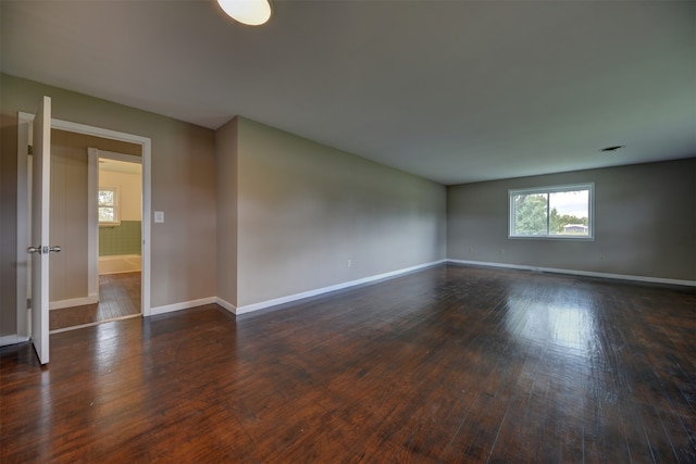 unfurnished room with dark hardwood / wood-style flooring