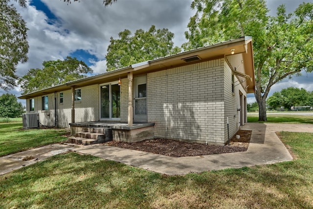 exterior space featuring a front lawn and central AC