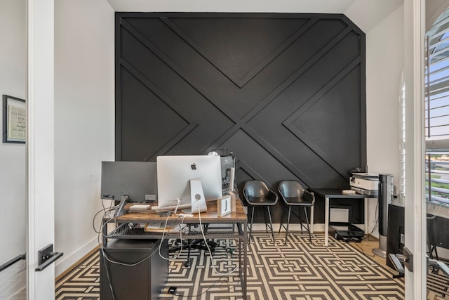 carpeted office with lofted ceiling