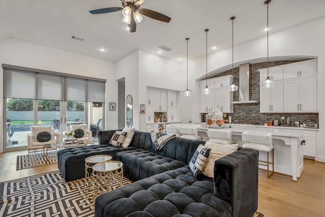 living room with ceiling fan and light hardwood / wood-style flooring