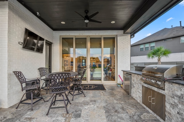 view of patio featuring exterior kitchen, area for grilling, and ceiling fan