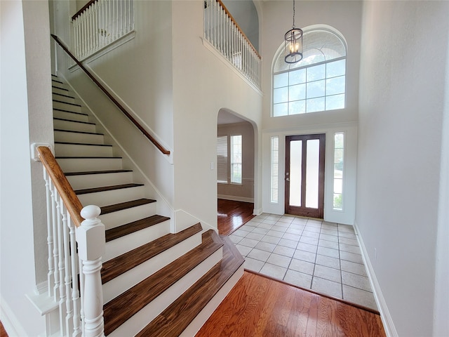 foyer with a high ceiling, light hardwood / wood-style flooring, and plenty of natural light