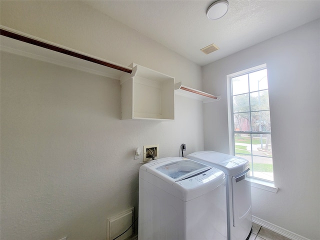 laundry area featuring washer and clothes dryer and light tile patterned floors