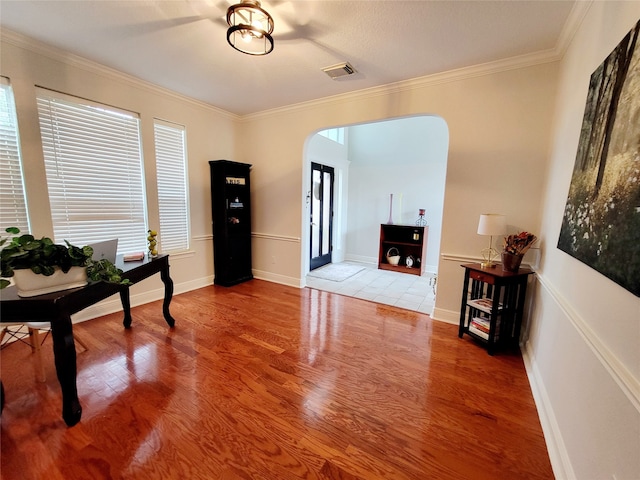 living area with crown molding and hardwood / wood-style flooring