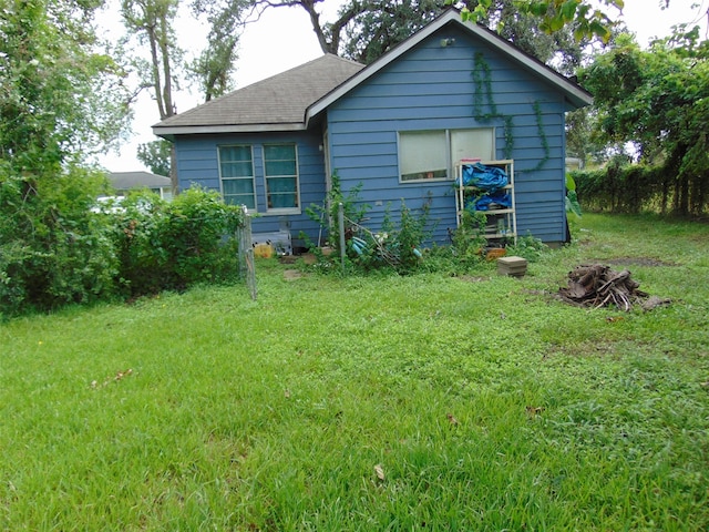 rear view of property featuring a lawn