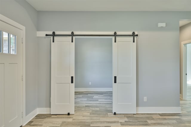 interior space with a barn door and light hardwood / wood-style floors