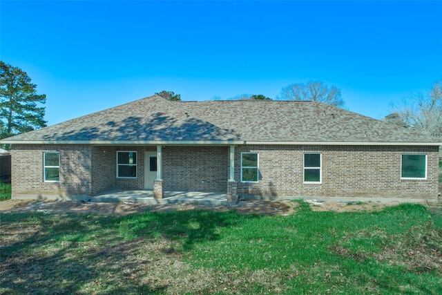 back of house with a lawn and a patio