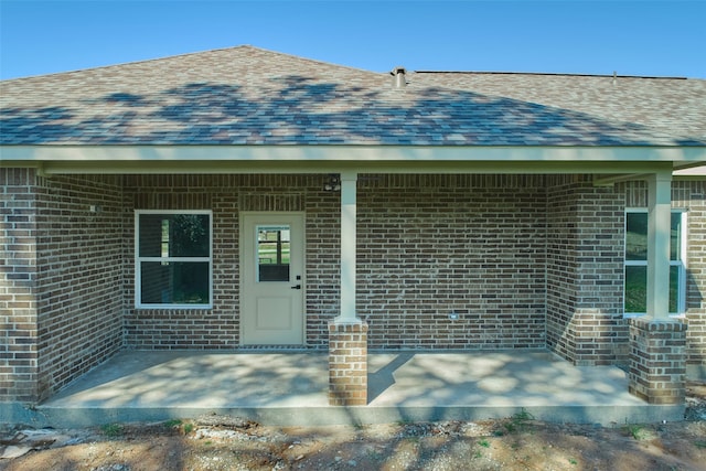 view of exterior entry with a patio