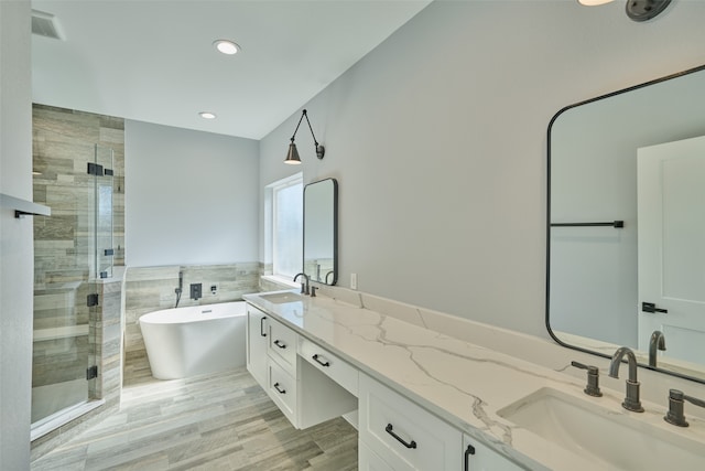 bathroom with hardwood / wood-style floors, separate shower and tub, and vanity