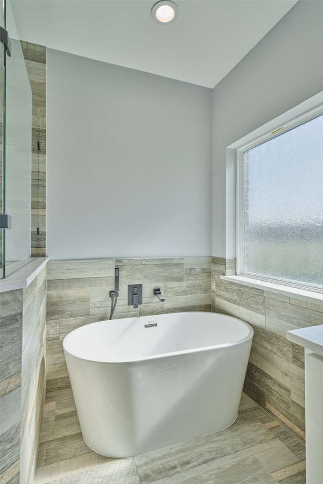 bathroom featuring tile walls, vanity, and plus walk in shower