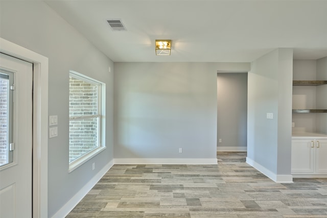 unfurnished room featuring light wood-type flooring and plenty of natural light