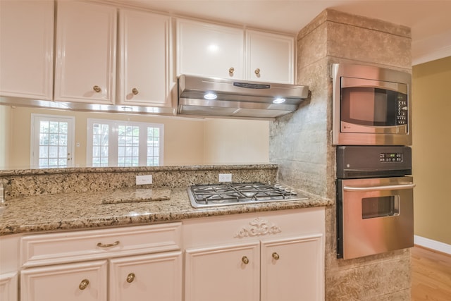 kitchen with appliances with stainless steel finishes, light hardwood / wood-style flooring, and white cabinetry