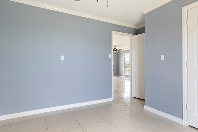 tiled spare room featuring ornamental molding and ceiling fan