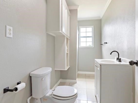 bathroom with vanity, toilet, ornamental molding, and tile patterned flooring