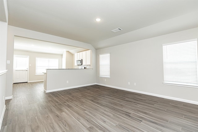 unfurnished living room with dark hardwood / wood-style flooring and lofted ceiling