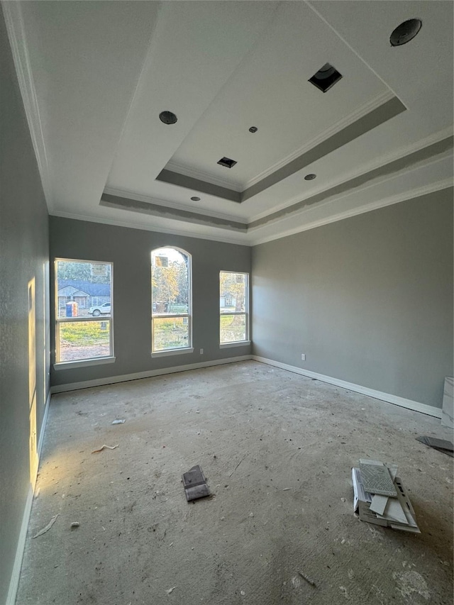 empty room with crown molding and a tray ceiling