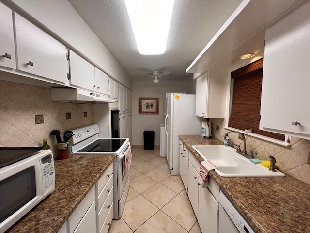 kitchen with white appliances, backsplash, sink, white cabinetry, and ceiling fan