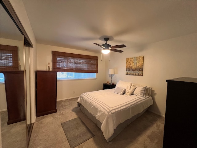 carpeted bedroom with ceiling fan and a closet