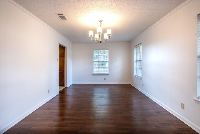 spare room featuring an inviting chandelier, dark hardwood / wood-style flooring, ornamental molding, and a textured ceiling