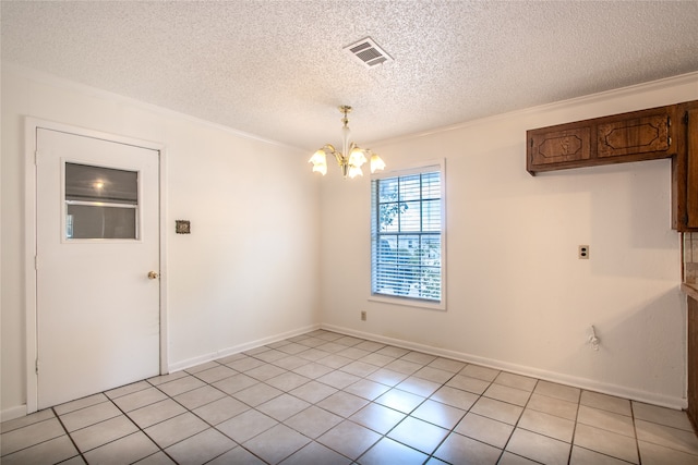 interior space featuring a textured ceiling, ornamental molding, light tile patterned floors, and an inviting chandelier