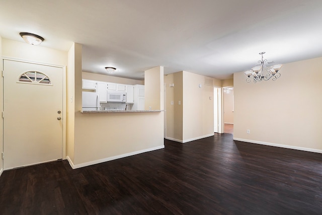 unfurnished living room featuring dark hardwood / wood-style floors and a notable chandelier