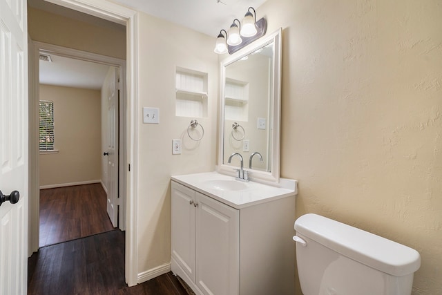 bathroom featuring wood-type flooring, vanity, and toilet