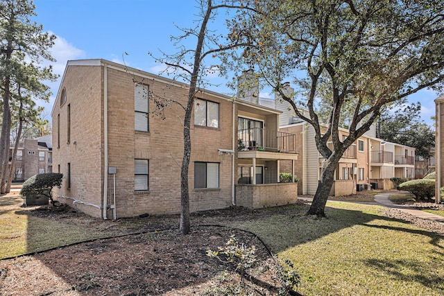 exterior space with a lawn and a balcony