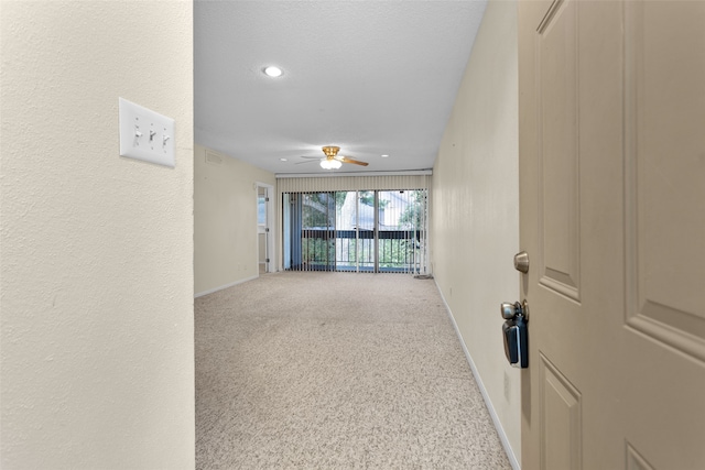 hallway featuring a textured ceiling and carpet flooring