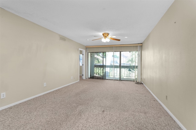 carpeted empty room featuring ceiling fan and a textured ceiling