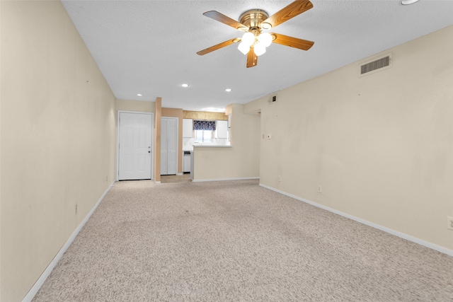 carpeted empty room with a textured ceiling and ceiling fan