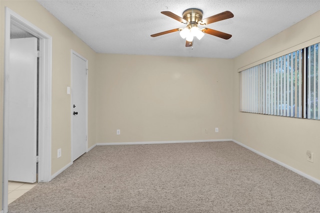 carpeted spare room featuring ceiling fan and a textured ceiling