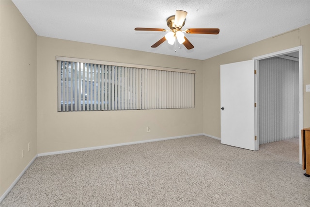 spare room with light colored carpet, ceiling fan, and a textured ceiling