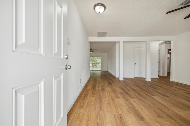 entryway with a textured ceiling, ceiling fan, and light hardwood / wood-style floors