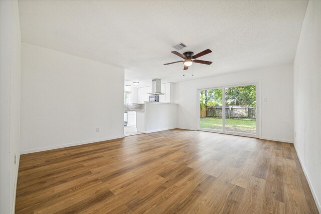 interior space featuring a textured ceiling, wood-type flooring, and ceiling fan