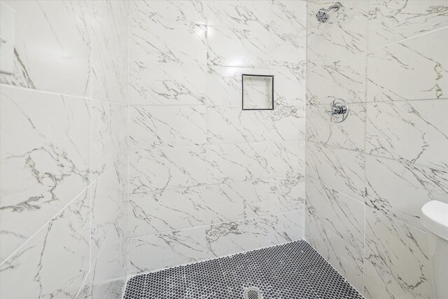 bathroom with toilet and tiled shower