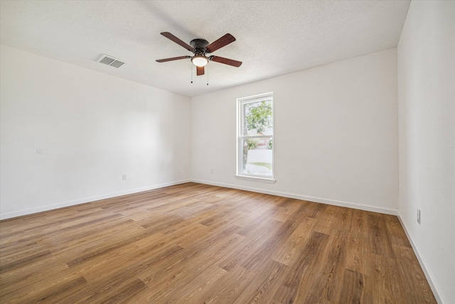 spare room featuring ceiling fan, light hardwood / wood-style floors, and a textured ceiling