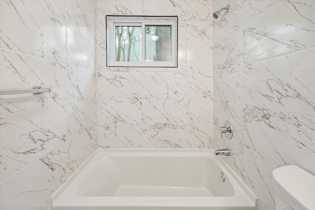 bathroom with tiled shower / bath and toilet