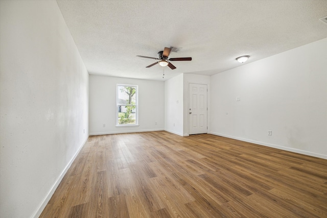 spare room with a textured ceiling, hardwood / wood-style flooring, and ceiling fan