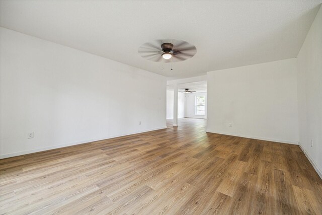 empty room with light hardwood / wood-style flooring and ceiling fan