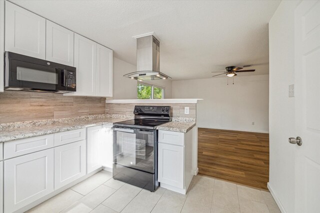 kitchen with white cabinetry, black appliances, island range hood, ceiling fan, and light hardwood / wood-style floors