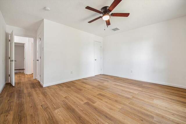 unfurnished room featuring a textured ceiling, ceiling fan, and light wood-type flooring