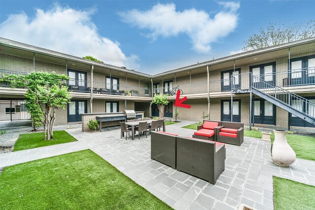 view of home's community with an outdoor living space, a patio area, and a lawn