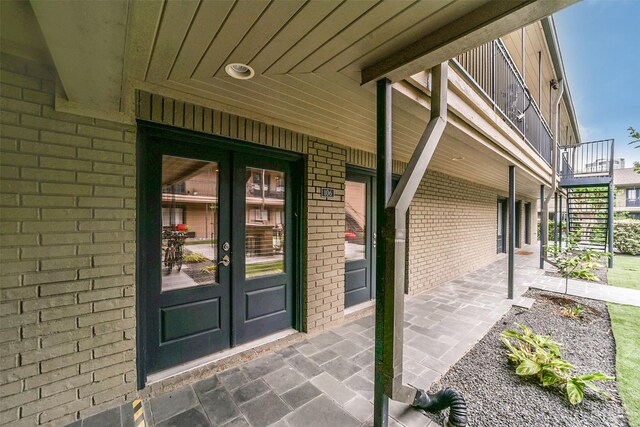 property entrance with a balcony and french doors