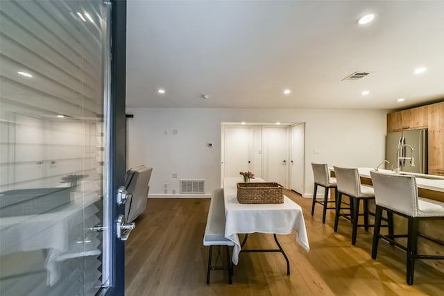 dining space featuring wood-type flooring and sink